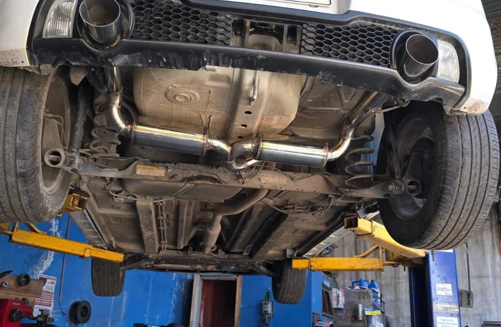 Silenciador central y doble salida vistos desde abajo en un Swift Sport